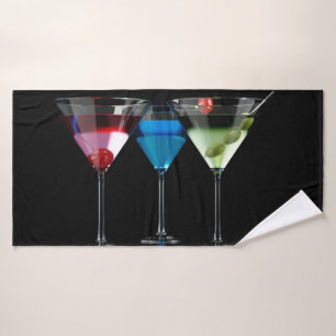 Verschiedene Cocktails in Martini-Brillen auf schw Badehandtuch