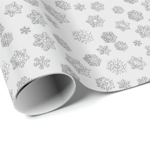 Versilbern Sie 3 d-Schneeflocken auf einem Geschenkpapier
