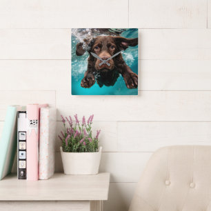 Verspielter Chocolate-Labrador schwimmt unter Wass Quadratische Wanduhr