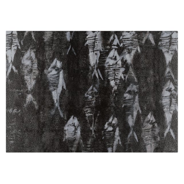 Versteinerte weiße Fische auf schwarzem Schneidebrett (Vorderseite)