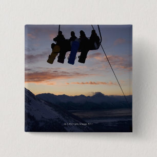 Vier Snowboarder sind auf einem Skilift silhouetti Button