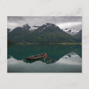 Vieux bateau à rames avec carte postale de montagn