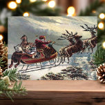 Vintag Flying Santa Sleigh Rentier Weihnachten<br><div class="desc">Vintage Weihnachtsfeiertagskarte "Santa Sleigh Rentier". Dieses Design zeigt einen Vintagen Santa-Claus,  der mit seinem Rentier in seinem Schlitten fliegt. Was für eine schöne Retro-Urlaubsszene.</div>