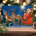 Vintage Santa Sleida Rentierferien Postkarte<br><div class="desc">Vintage Santa Sleigh Rentier Holiday Postcard. Schöner Jahrgang Weihnachten Weihnachten Weihnachten Postkarte. Dieses Design zeigt den Weihnachtsmann in seinem Schlitten,  der seine Rentiere durch einen mondbeleuchteten Nachthimmel führt. Was für eine schöne Urlaubsszene!</div>