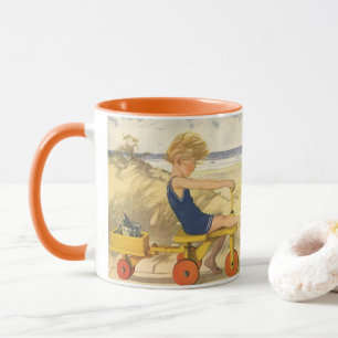 Vintager Junge spielt am Strand mit Sandspielzeug Tasse