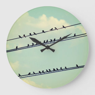 Vögel auf Leitungen, vintage blauer Himmel. Große Wanduhr