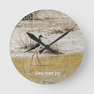 Vogel watet im flachen Wasser Runde Wanduhr