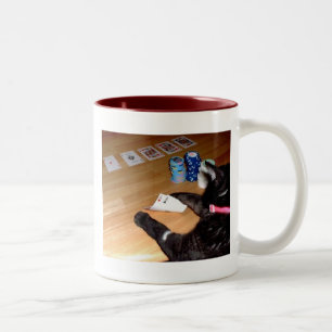 Vrai chat jouant la tasse de café de tisonnier