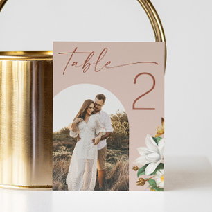 Warme Rosé-Beige-Skript-Blumen-Hochzeit. Bogenfoto Tischnummer