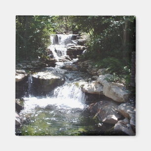 Wasserfall strömt über Felsen in einen ruhigen Poo Magnet