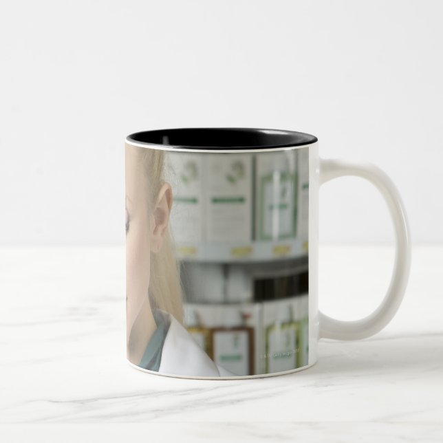 Weiblicher Apotheker, der herein Medizin Zweifarbige Tasse (Rechts)