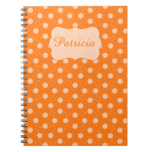 Weiche pfirsichfarbene-beige Blumen auf orangefarb Notizblock