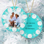 Weihnachts Beach Wart Sand Dollar Starfish Keramik Ornament<br><div class="desc">Ein Kranz aus weißem Sand,  Seestern und Aqua-Glitzer-Korallen umrahmt das Foto der Familie,  das sich vor diesem Thema des Strandes verziert,  mit einem Aqua-blauen Hintergrund,  Familienname,  Jahr und Frohe Weihnachten auf der Rückseite. Bitte kontaktieren Sie mich über den Zazzle Chat,  wenn Sie passende Produkte,  Designschwächen oder andere Farbtöne benötigen.</div>