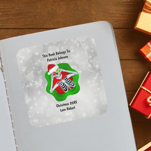 Weihnachts-Skelett-Ornamente Helle Rot Grün Quadratischer Aufkleber (Cute Skeleton holding ornaments for eyes Santa Hat in green Red splatter on white book plate sticker)