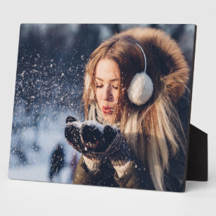 Weihnachts-Winter-Mädchen pustet Schnee in ihrer H Fotoplatte