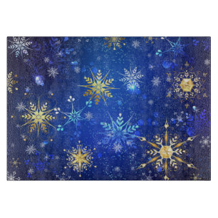 Weihnachtsblauer Hintergrund mit goldenen Schneefl Schneidebrett