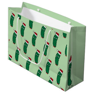 Weihnachtsdillgurke mit einem Weihnachtsmannhut Große Geschenktüte