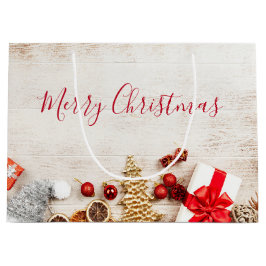 Weihnachtsgeschenkartikel auf einem rustikalen Hol Große Geschenktüte