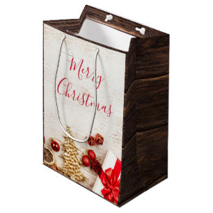 Weihnachtsgeschenkartikel auf einem rustikalen Hol Mittlere Geschenktüte