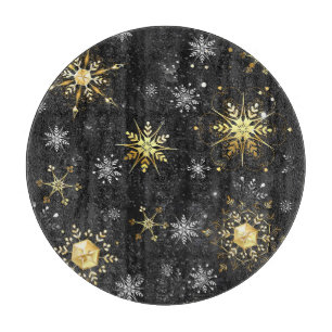 Weihnachtsgold-Schneeflocken auf schwarzem Hinterg Schneidebrett