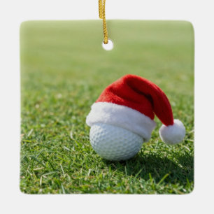 Weihnachtsgolfball mit Santa-Hut auf Tee auf Grün Keramikornament