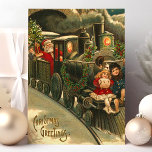 Weihnachtsgrüße Zug Vintag Feiertagspostkarte<br><div class="desc">Schöne Weihnachtsbahn Weihnachtsmann Postkarte. "Weihnachtsgrüße" geschrieben in der unteren links Ecke. In diesem Design befindet sich ein Schulleiter des Weihnachtsmanns,  der zwei kleine Kinder auf einer Fahrt vor dem Zug hat.</div>