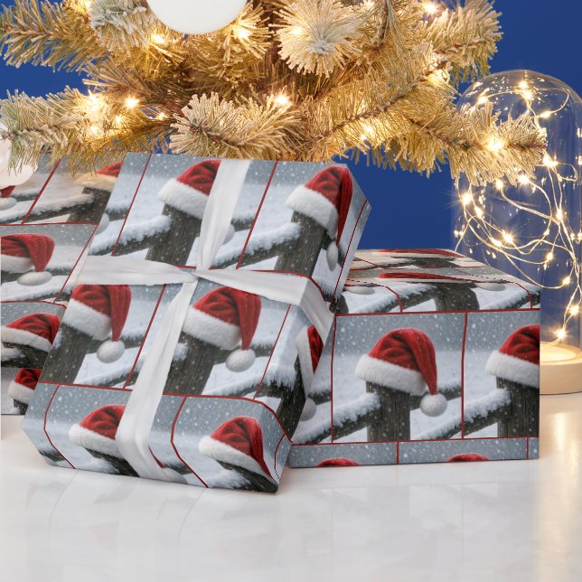 Weihnachtsmannmütze auf einem schneebedeckten Zaun Geschenkpapier (Feiertage)