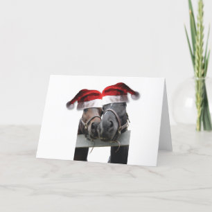 Weihnachtspferde mit Weihnachtsmannmützen Feiertagskarte