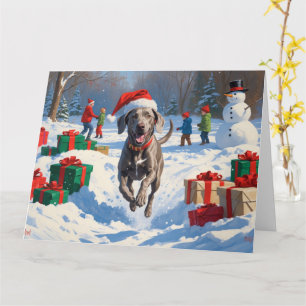 Weimaraner läuft im Schnee mit Weihnachtsmütze Karte