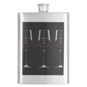 Weingläser mit Rotwein auf schwarz Flachmann