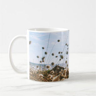 WEISSE BLUME IN DER NÄHE DES WASSERKÖRPERS UNTER KAFFEETASSE