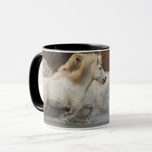Weiße Camargue-Pferde laufen im Wasser Tasse