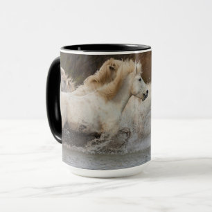 Weiße Camargue-Pferde laufen im Wasser Tasse