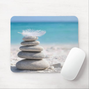 Weiße Feder auf einem Strandsteinhaufen Mousepad