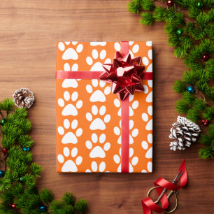 Weiße Hunde-/Katzen-/Tierpfotenabdrücke auf Orange Geschenkpapier