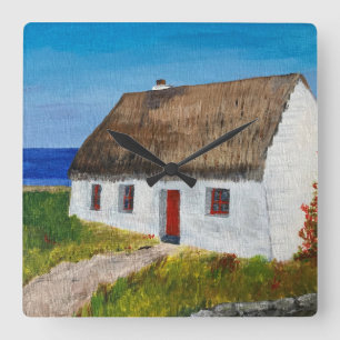 Weiße Hütte mit Blick aufs Meer Quadratische Wanduhr