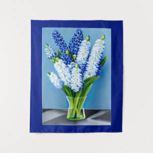 Weiße Hyazinthen in einer Glasvase auf blau Wandteppich