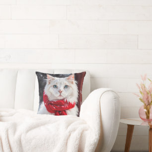 Weiße Katze mit rotem Wintertraf Kissen