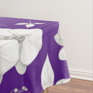 Weiße Orchidee auf Lila Tischdecke