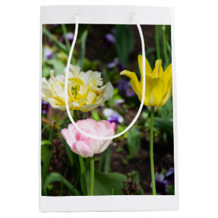 Weiße, rosa und gelbe Tulpen im Garten Mittlere Geschenktüte