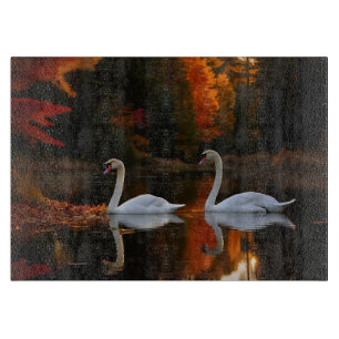 Weiße Schwäne schlängeln über den Herbstteich Schneidebrett