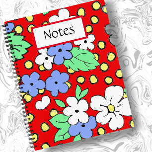Weiße und blaue Blumen auf einem roten Spiralheft Notizbuch