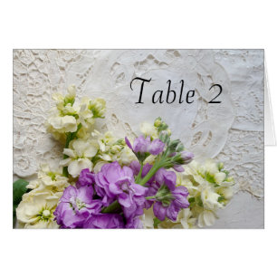 Weiße und violette Blumen an alter Spitze