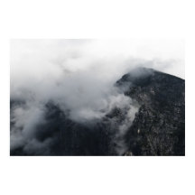 Weiße Wolken über den dunklen felsigen Bergen
