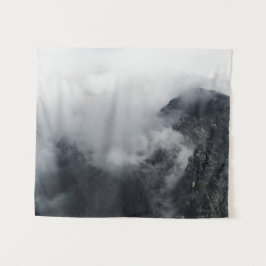 Weiße Wolken über den dunklen felsigen Bergen Wandteppich