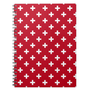 Weißer Polka kreuzt auf rot Notizblock