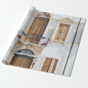 WEIßES BETONGEBÄUDE MIT HOLZTÜREN UND WIND GESCHENKPAPIER