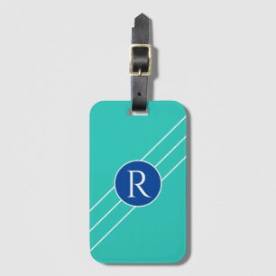 Weißes Monogramm in blauem Kreis, diagonale Linien Gepäckanhänger