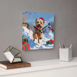 Wheaten Terrier läuft im Schnee mit Weihnachtshut Quadratische Wanduhr
