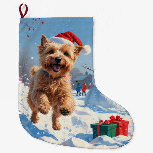Wheaten Terrier läuft im Schnee mit Weihnachtsmütz Großer Weihnachtsstrumpf